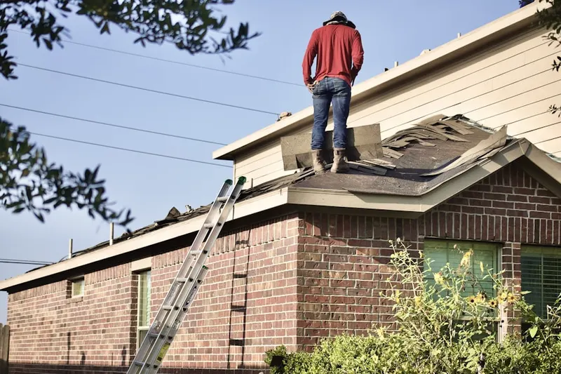 Professional roofer working on a residential roof in West Lawn